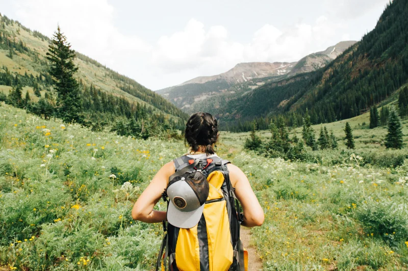 Hiker reviewing a topographical map and compass on a rocky mountain summit